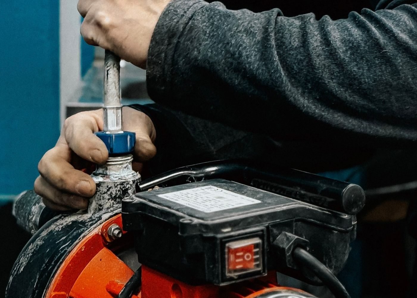 Técnico ajustando a conexão de uma bomba pressurizadora de água